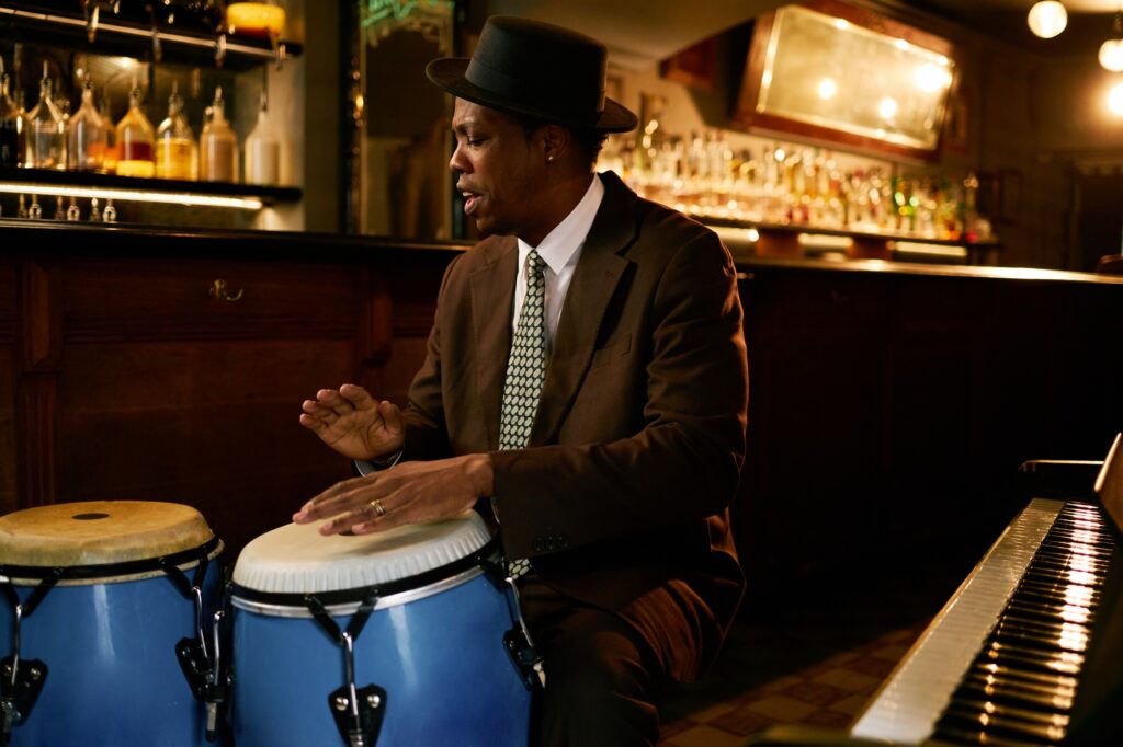 Black Male Musician Improvising on Conga Drums Playing Jazz in Bar